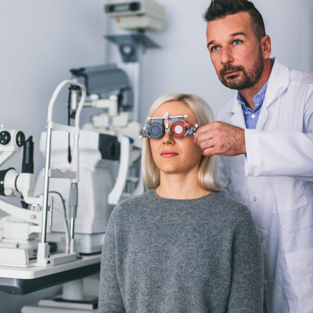 Optician checking patient’s eyesight with trial frame. Optician checking patient's eyesight with trial frame. Doctor's appointment and medical test.